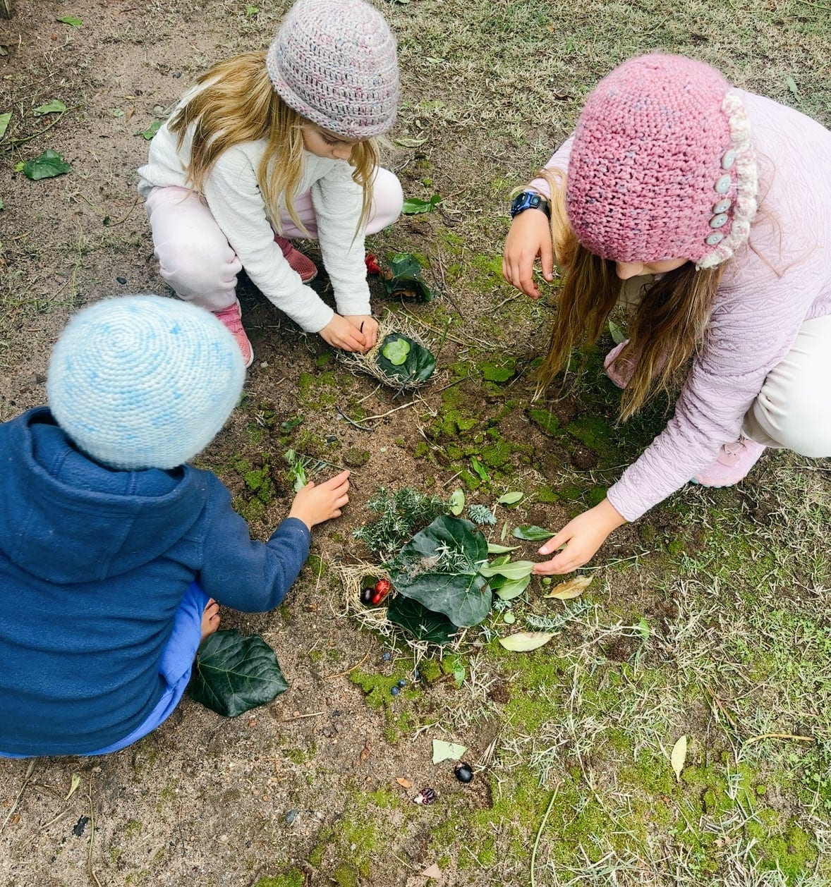 Three of the children picking vegetables in the garden